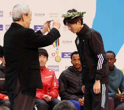優勝し松本正義大阪陸協会長（左）からメダルをかけてもらう平林清澄（撮影・加藤哉）