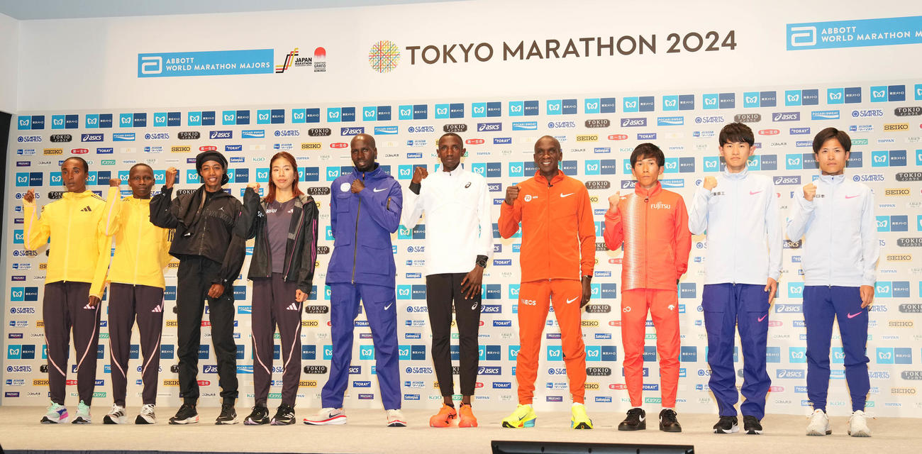 東京マラソン2024プレスカンファレンスのフォトセッションで笑顔の招待選手たち。左からシャンクレ、ワンジル、ハッサン、新谷、キプラガト、ゲティッチ、キプチョゲ、鈴木、山下、其田（撮影・鈴木みどり）