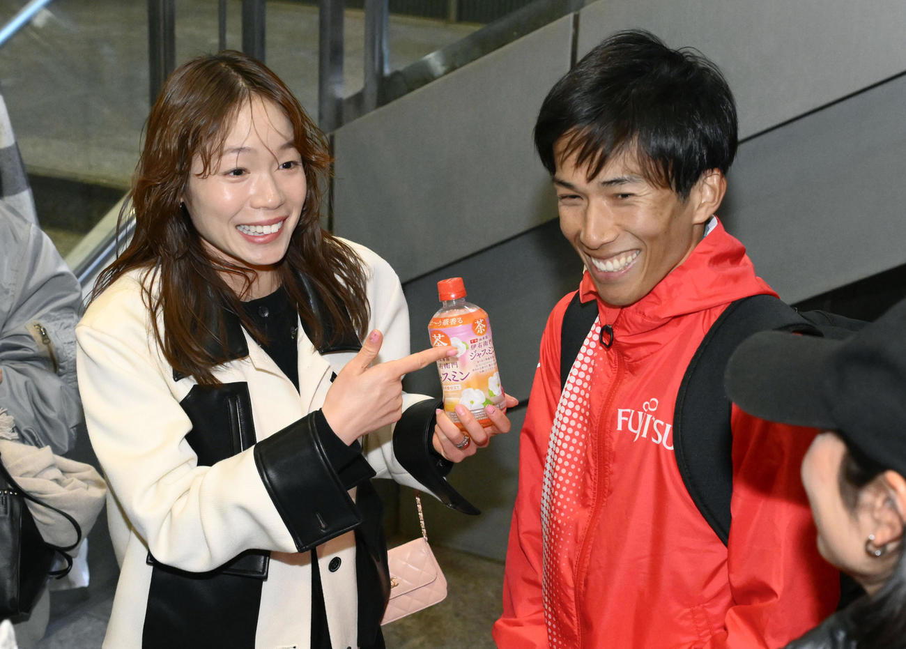 東京マラソンを男子28位で終えた夫の鈴木健吾（右）と笑顔で言葉を交わす一山麻緒（共同）