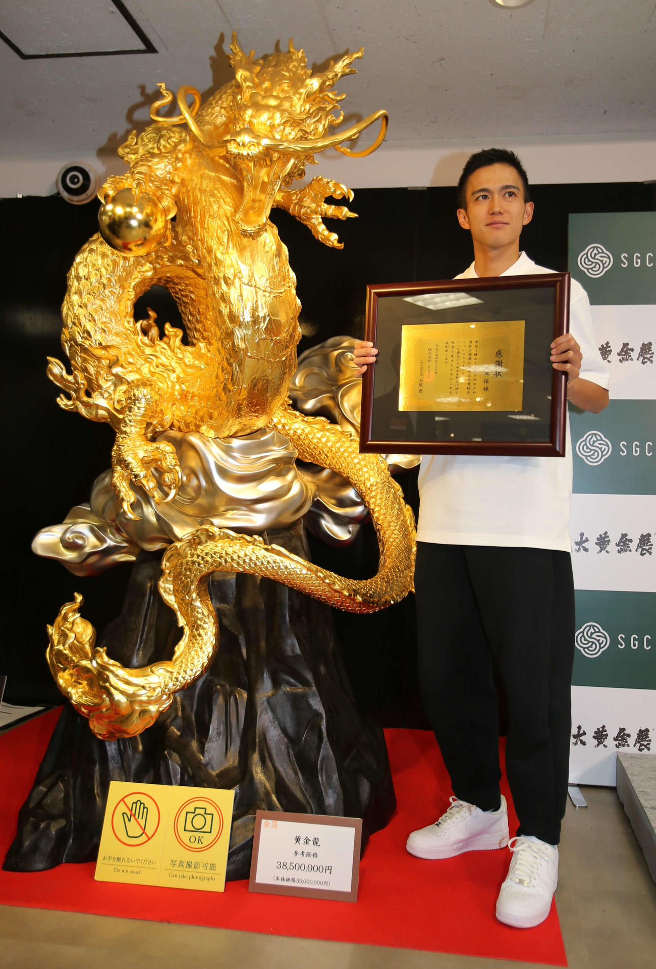 税込み3850万円の黄金龍の横で、金の感謝状を披露する大迫（撮影・中島洋尚）