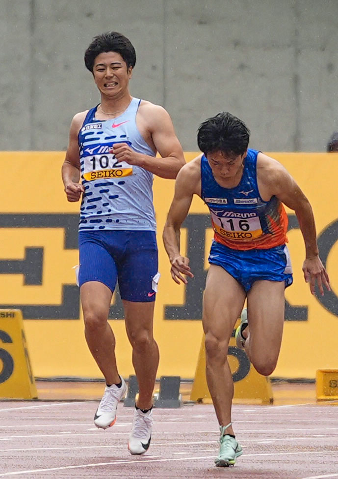 男子100 メートル 予選で、スタート直後に途中棄権した多田修平（左）（共同）