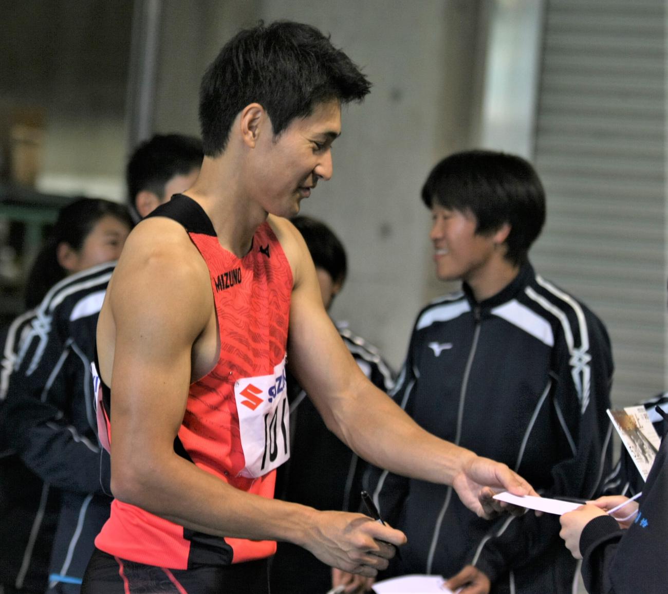 静岡国際陸上　男子200メートル決勝後に地元・静岡の子どもたちへサインをする飯塚（撮影・藤塚大輔）