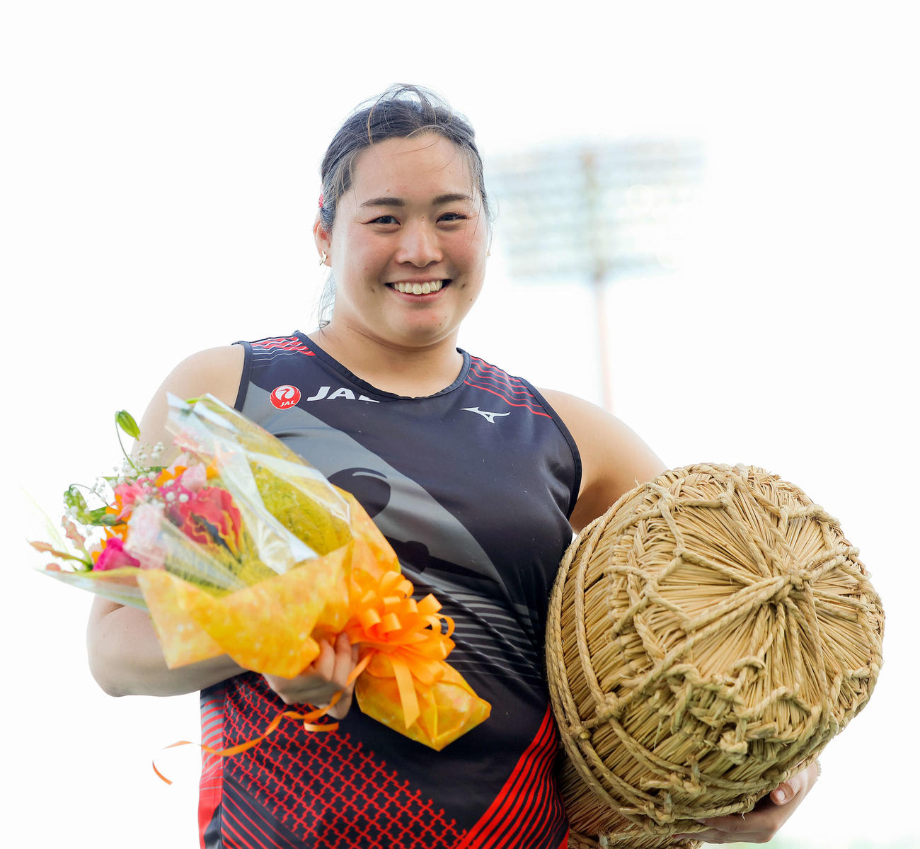 大会MVPの表彰式で、花束と米俵を手に笑顔を見せる北口（撮影・河田真司）