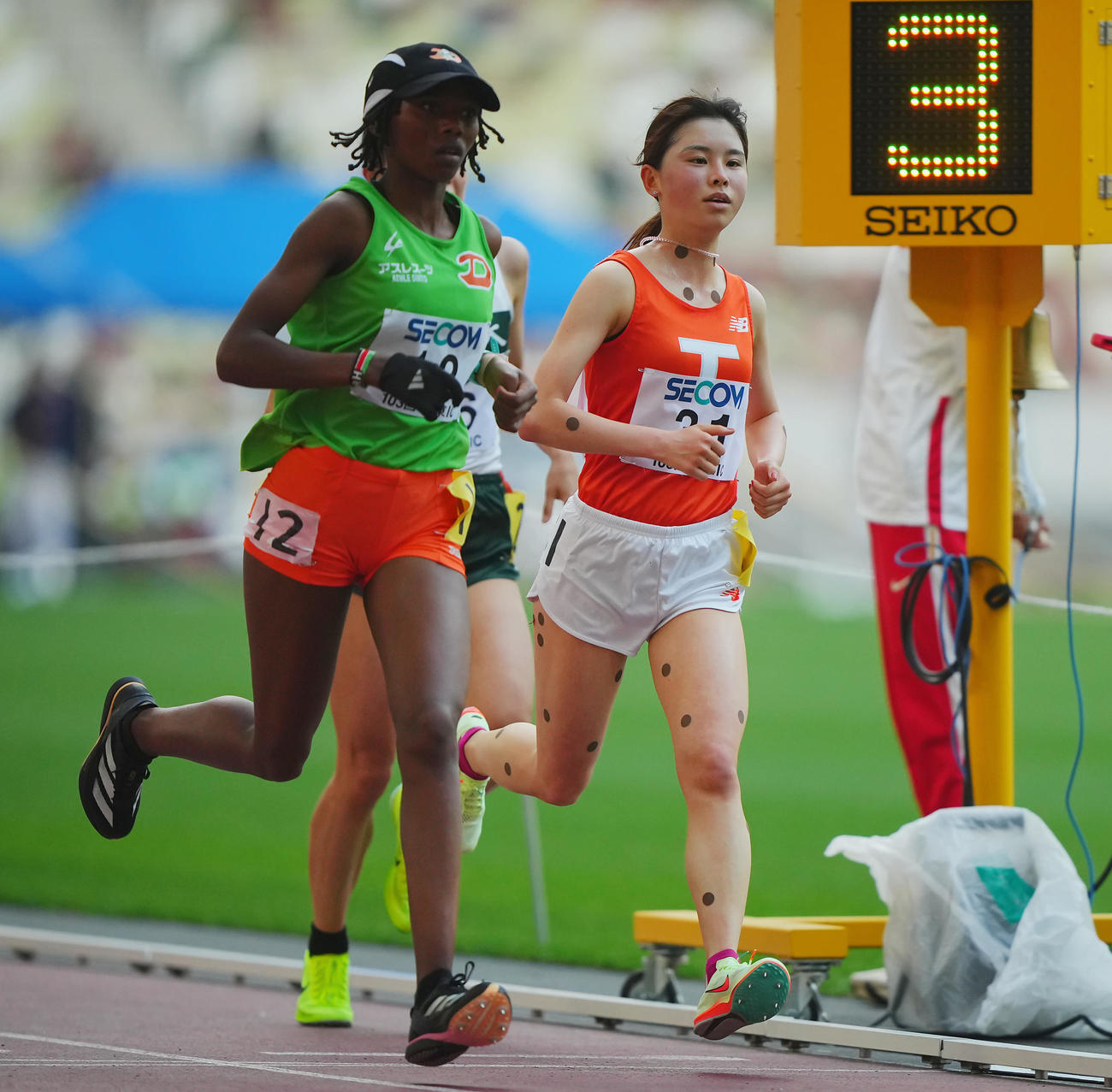 女子1万メートル決勝、レース終盤に1位のワンジル（左）に追い抜かれる不破（撮影・垰建太）