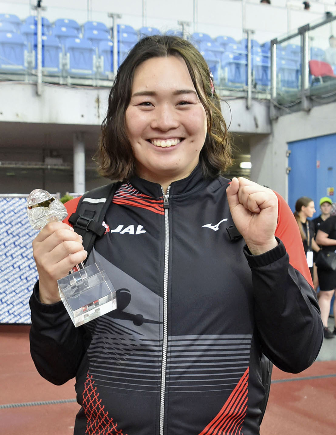 女子やり投げで優勝し、トロフィーを手に笑顔を見せる北口榛花（共同）