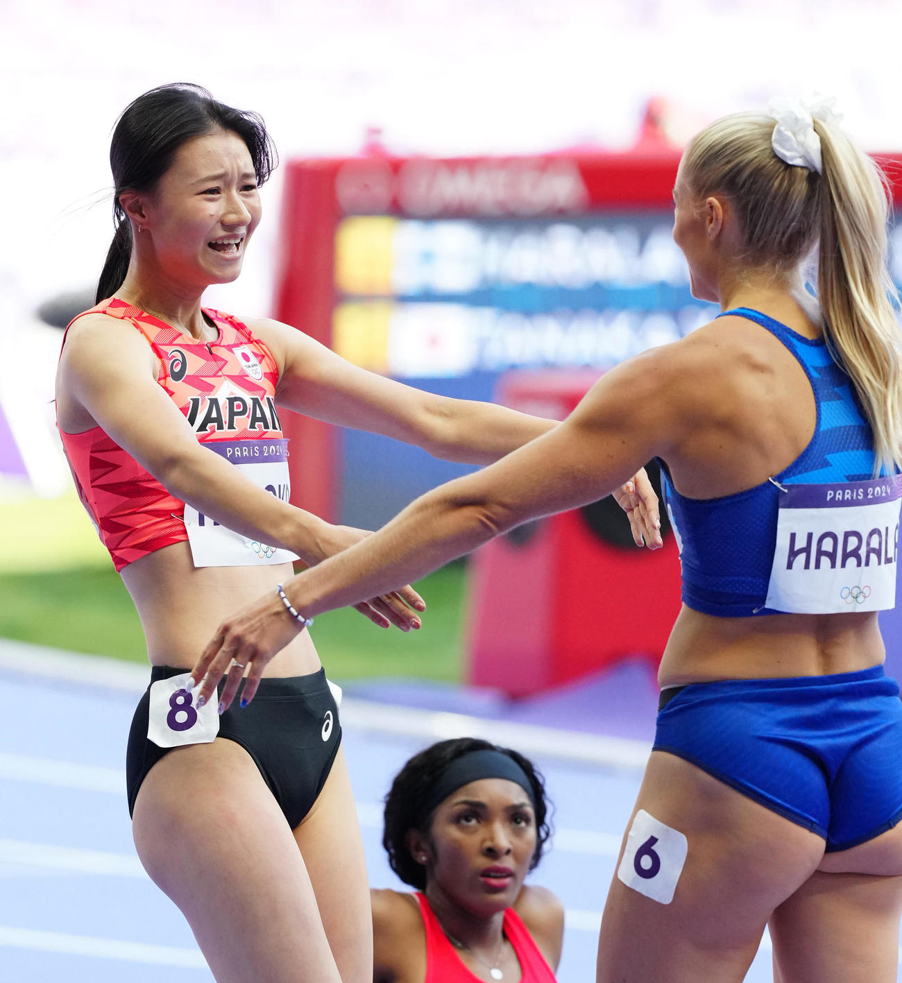 パリ五輪　陸上女子100メートル障害敗者復活戦　準決勝進出が決まり、フィンランドの選手と喜ぶ田中佑美＝2024年8月8日（現地時間）