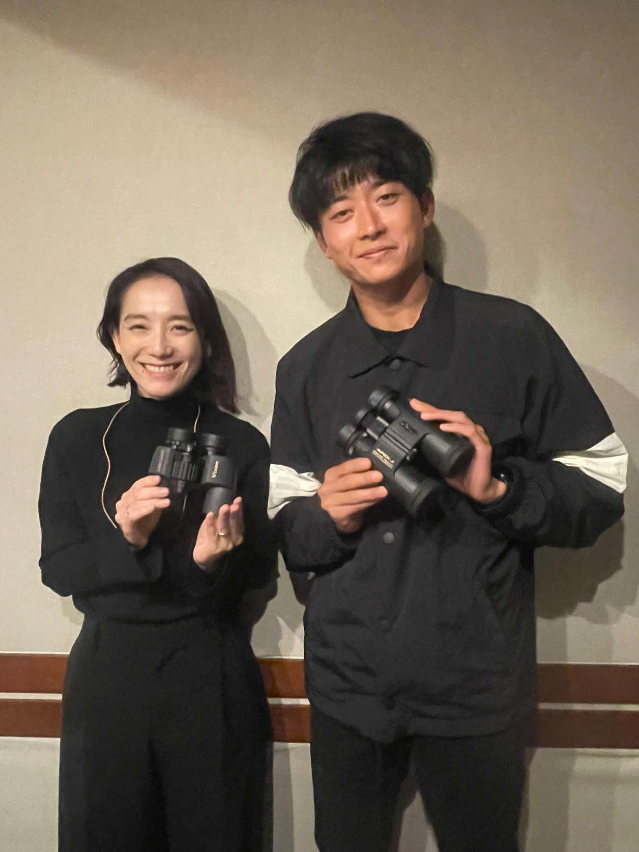 双眼鏡を手に笑顔をみせる陸上男子日本代表の佐藤拳太郎（右）と篠原ともえさん