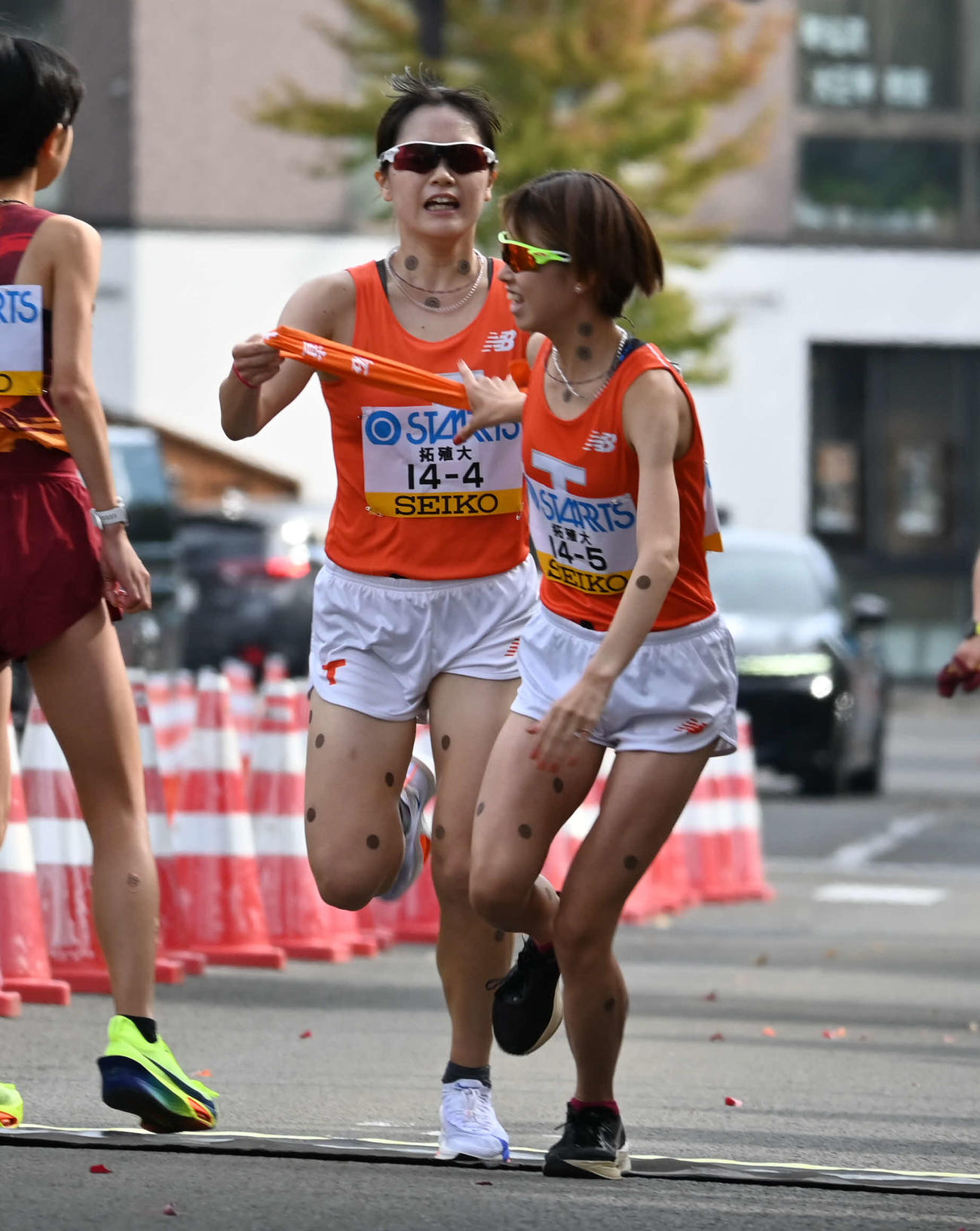 タスキを受け取る拓大の不破聖衣来（右）（撮影・飯岡大暉）