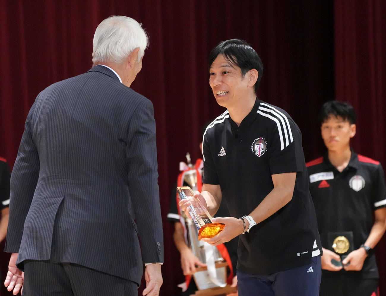 優勝監督賞を受賞し笑顔を見せる国学院大の前田康弘監督（右）（撮影・森本幸一）