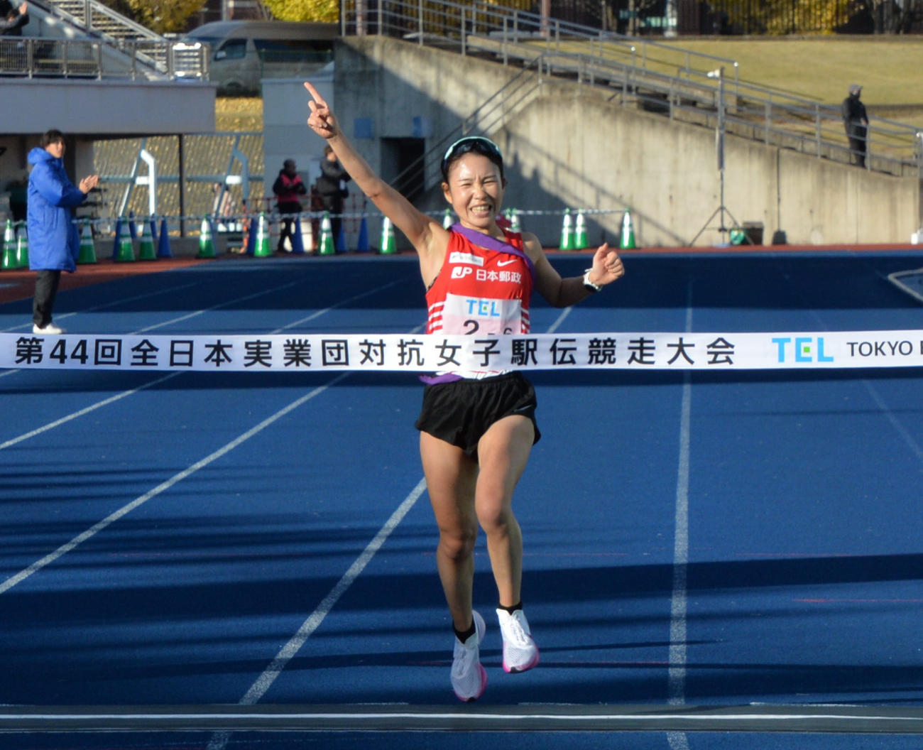 JP日本郵政グループのアンカー・太田が人差し指を突き立て、優勝のゴールテープを切る（撮影・浜本神威）