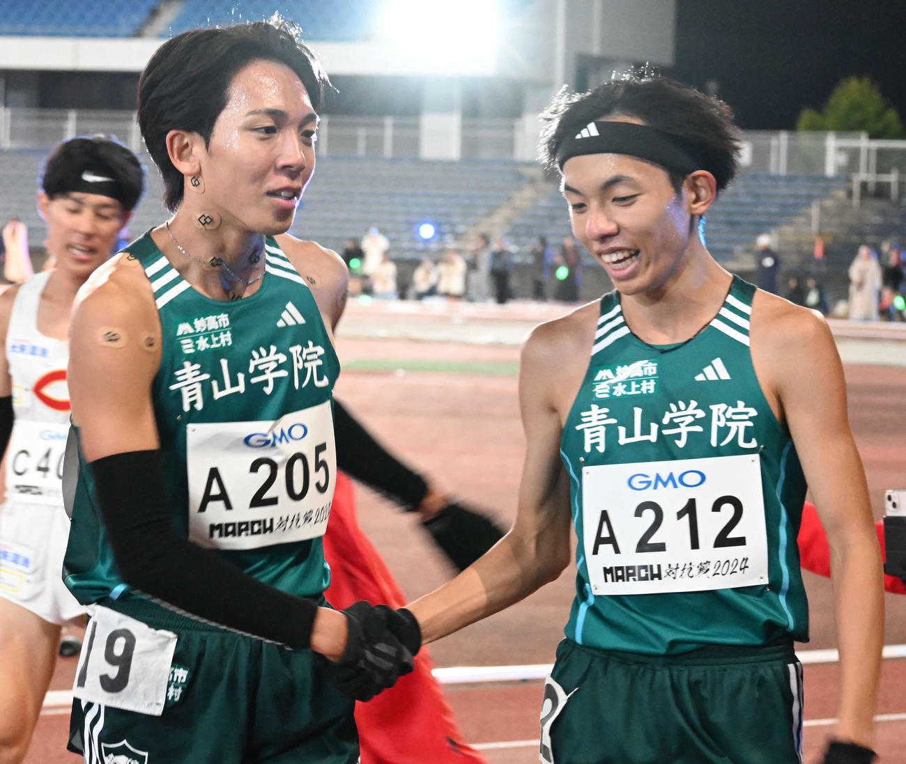 4組のトップでゴールした青学大の鶴川（左）は黒田朝と握手（撮影・飯岡大暉）