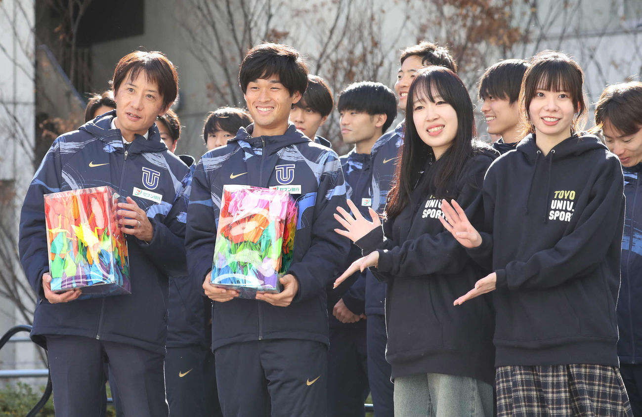 東洋大学の箱根駅伝壮行会で生徒たちから必勝祈願の千羽鶴を受けとった酒井監督（左）と主将の梅崎（同2人目）（撮影・丹羽敏通）