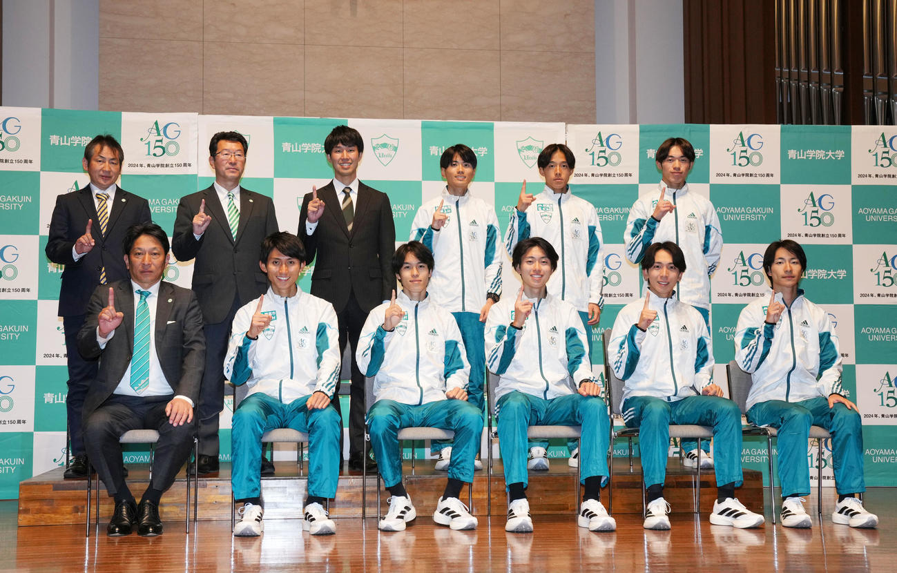 笑顔で1本指を立てる青学大の選手たち。前列左から原監督、田中、太田、白石光、鶴川、野村、後列左から田幸コーチ、安藤コーチ、伊藤コーチ、若林宏、塩出、平松（撮影・横山健太）