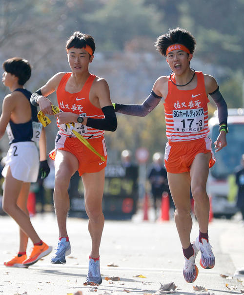 力走する佐久長聖の3区・佐々木（右）は4区・篠にタスキを渡し声を出す（撮影・上山淳一）