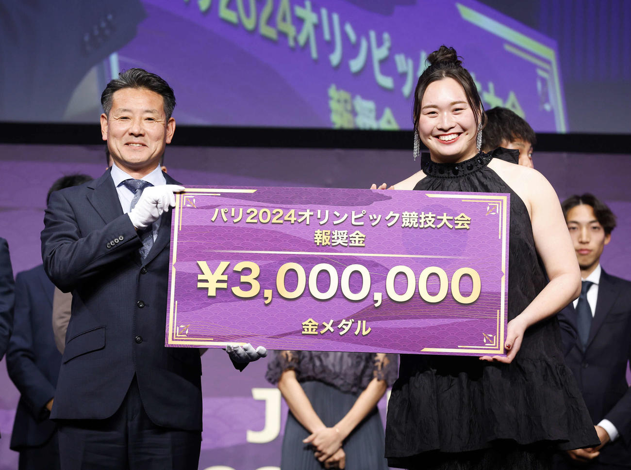 日本陸連アスレティックス・アワード2024でアスリート・オブ・ザ・イヤーを受賞した女子やり投げの北口（右）はパリ五輪金メダルの報奨金300万円のボードを手に笑顔を見せる（日本陸上競技連盟／フォート・キシモト）