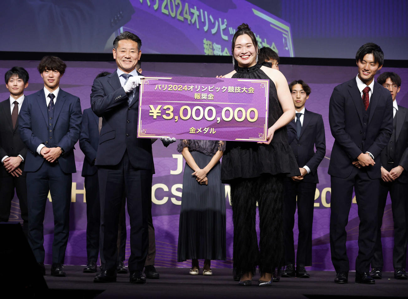 日本陸連アスレティックス・アワード2024でアスリート・オブ・ザ・イヤーを受賞した女子やり投げの北口（右）はパリ五輪金メダルの報奨金300万円のボードを手に笑顔を見せる（日本陸上競技連盟／フォート・キシモト）