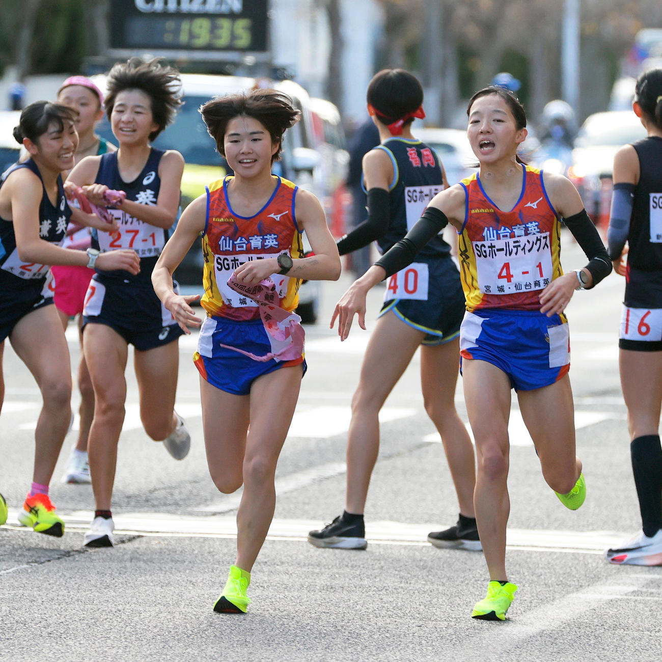仙台育英の1区・長岡（右）は2区・渡辺（手前）にタスキを渡す（撮影・上山淳一）