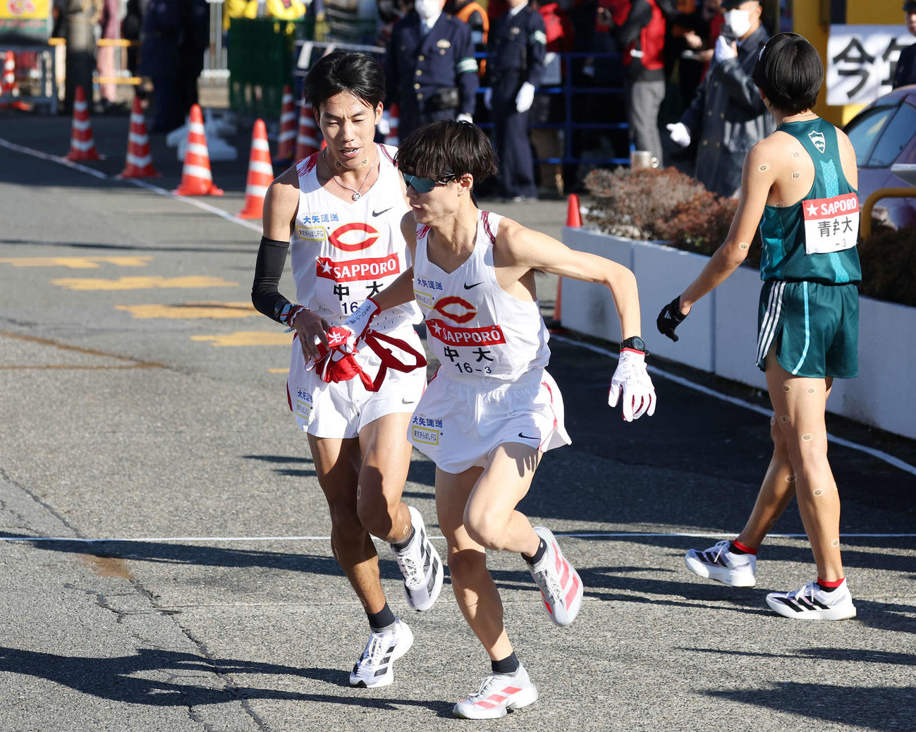 戸塚中継所で中大2区溜池（左）は3区本間にトップでタスキをつなぐ（撮影・宮地輝）