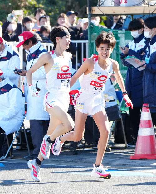 平塚中継所、首位でタスキリレーする中大の選手たち。左は3区本間、右は4区白川（撮影・江口和貴）