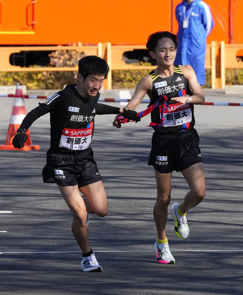 創価大4区野沢（右）は5区山口に小田原中継所でたすきを渡す（撮影・鈴木みどり）