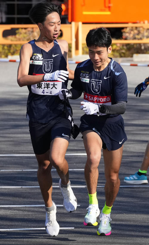 東洋大4区岸本（左）は5区宮崎に小田原中継所でたすきを渡す（撮影・鈴木みどり）