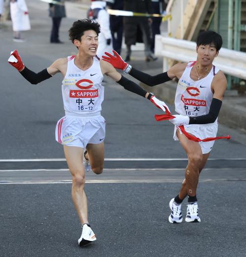 鶴見中継所を1位でタスキリレーする中大1区吉居（左）と2区溜池（撮影・河田真司）