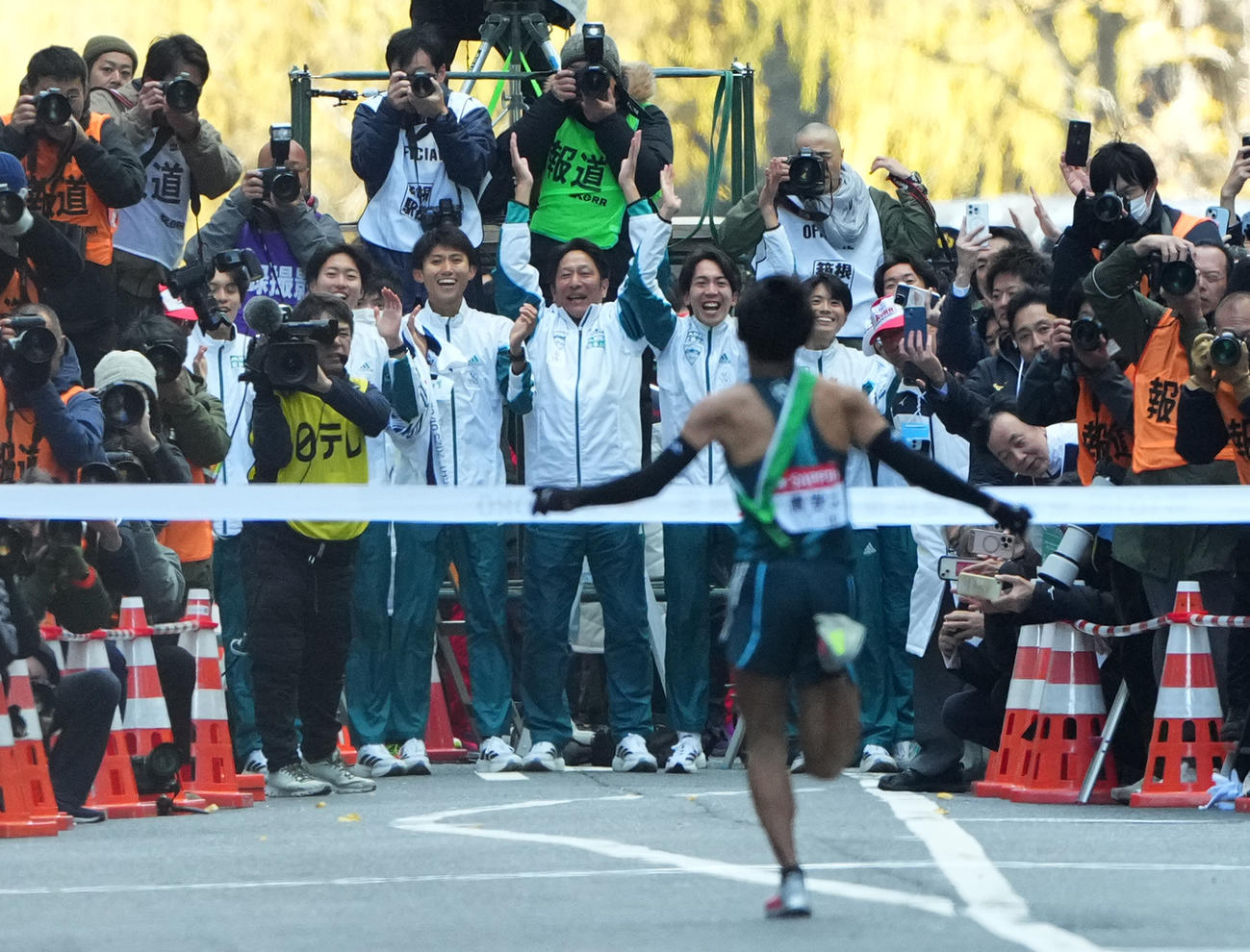 1位でゴールテープをきる青学大10区小河原陽琉を迎える原監督（中央）ら選手たち（撮影・菅敏）