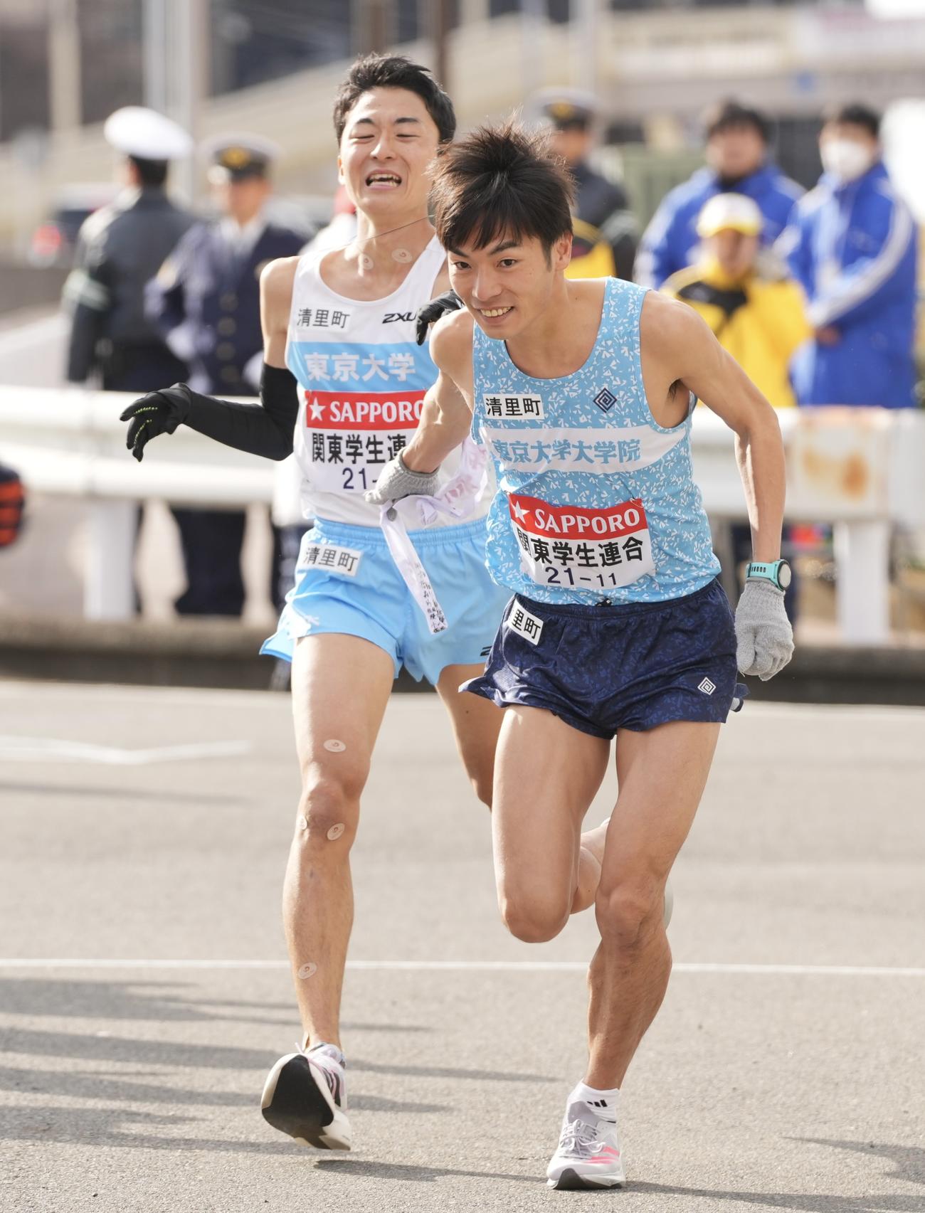 戸塚中継所でタスキリレーする関東学生連合8区の東大・秋吉（左）と9区の東大大学院・古川（撮影・垰建太）