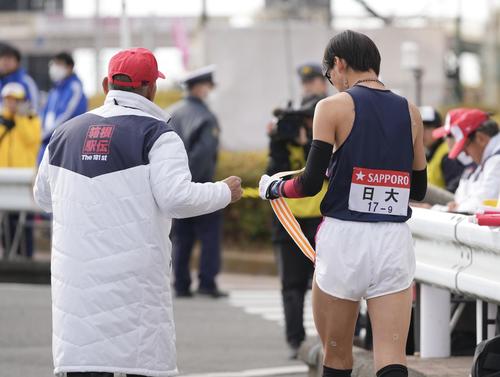 戸塚中継所で繰り上げのタスキを渡される日大9区小路（右）（撮影・垰建太）
