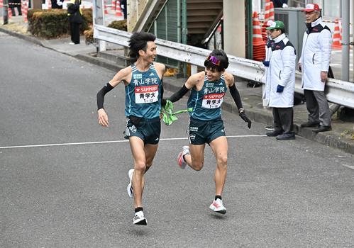 鶴見中継所でトップでタスキリレーする青学大の9区田中（左）と10区小河原（撮影・滝沢徹郎）