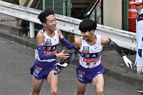 鶴見中継所でタスキリレーする駒大の9区村上（左）と10区小山（撮影・滝沢徹郎）