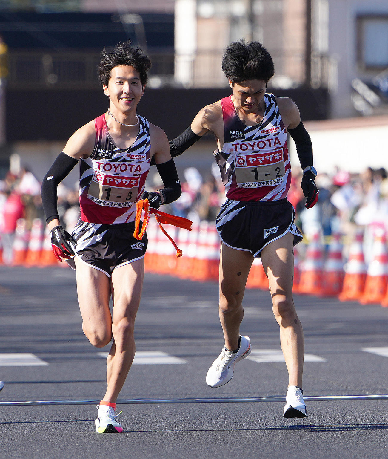 第2中継所でタスキリレーするトヨタ自動車の2区鈴木（右）と3区太田（撮影・足立雅史）
