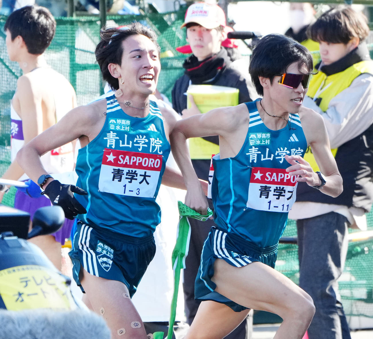 平塚中継所で青学大3区鶴川（左）からタスキを受け取った4区太田（撮影・江口和貴）