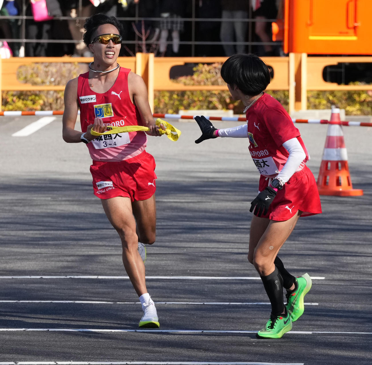 城西大4区林（左）は5区斎藤に小田原中継所でたすきを渡す（撮影・鈴木みどり）