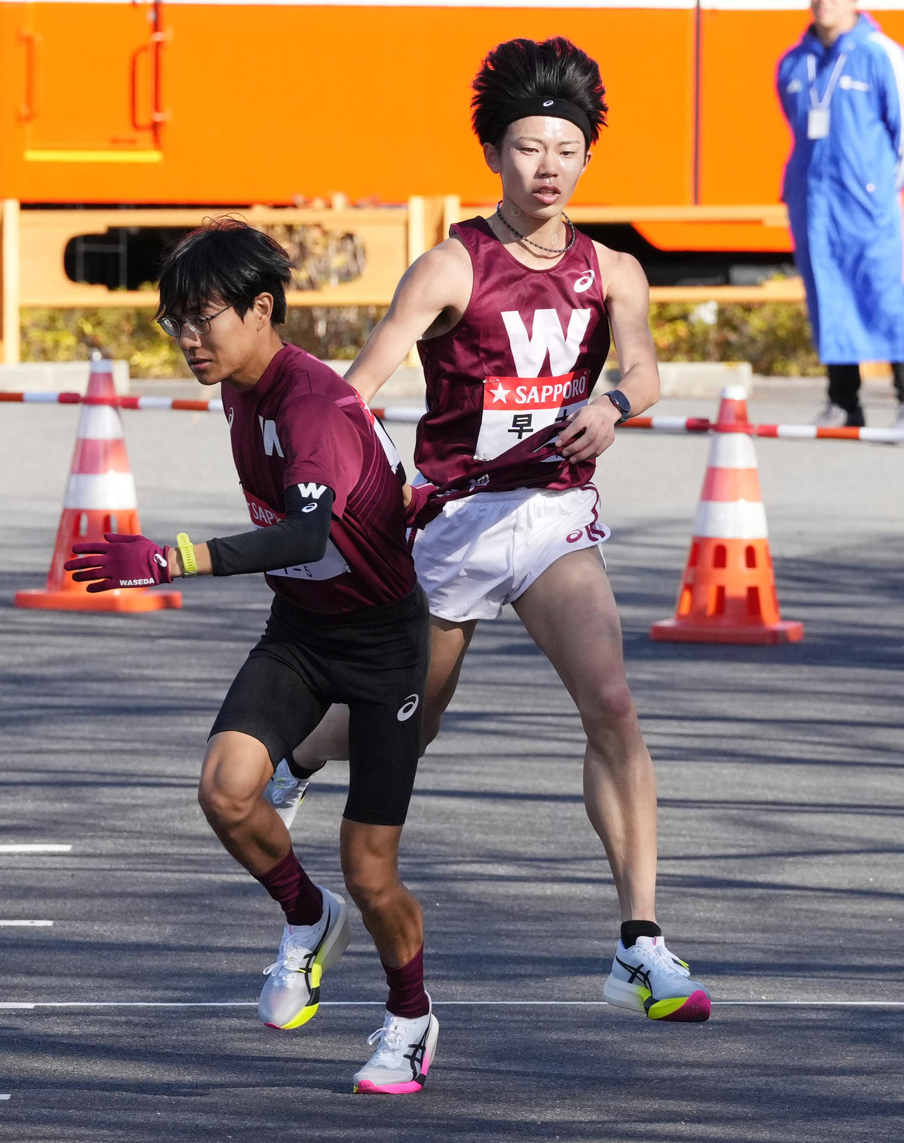 早大4区長屋（右）は5区工藤に小田原中継所でたすきを渡す（撮影・鈴木みどり）