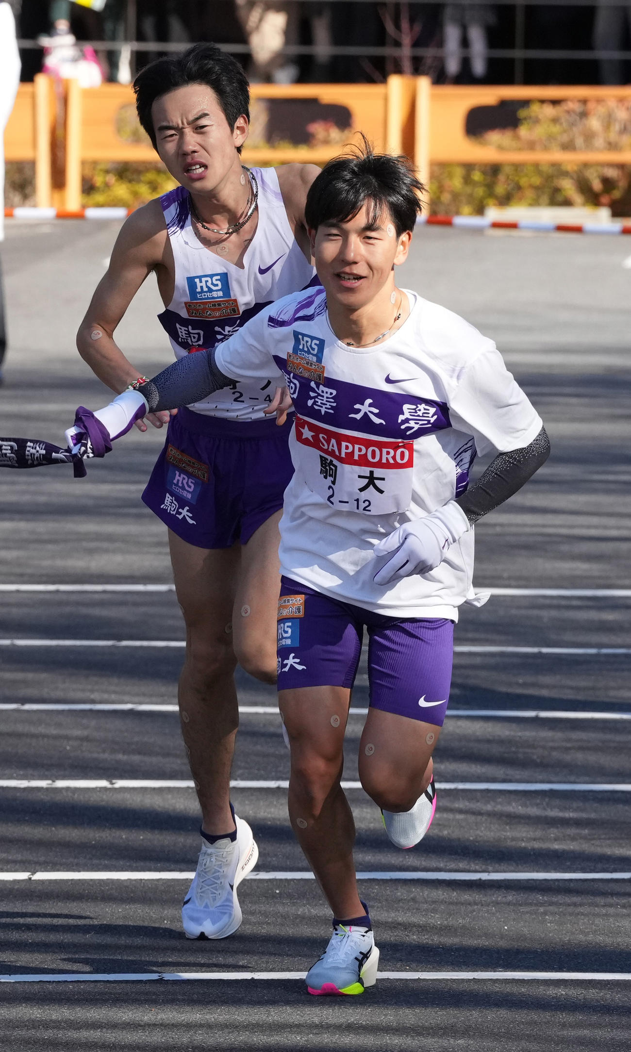 駒大4区桑田（左）は5区山川に小田原中継所でたすきを渡す（撮影・鈴木みどり）