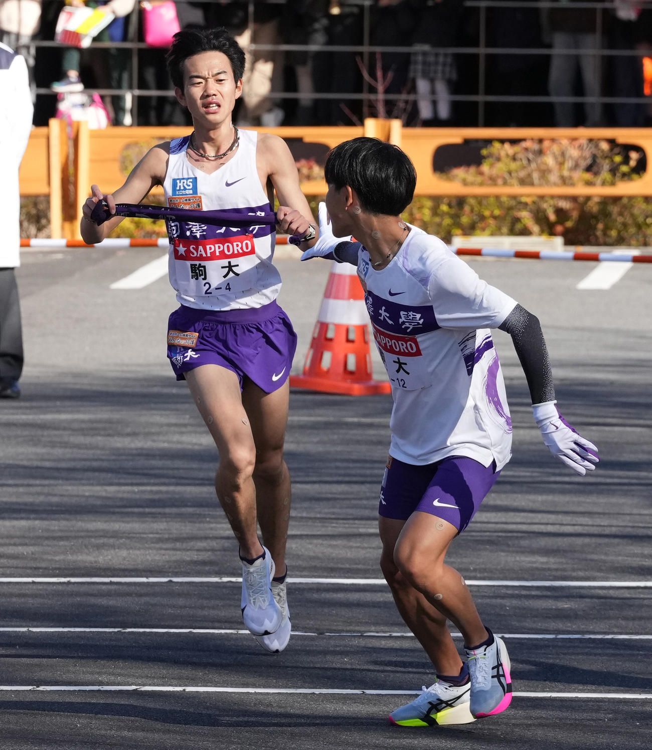 駒大4区桑田（左）は5区山川に小田原中継所でたすきを渡す（撮影・鈴木みどり）