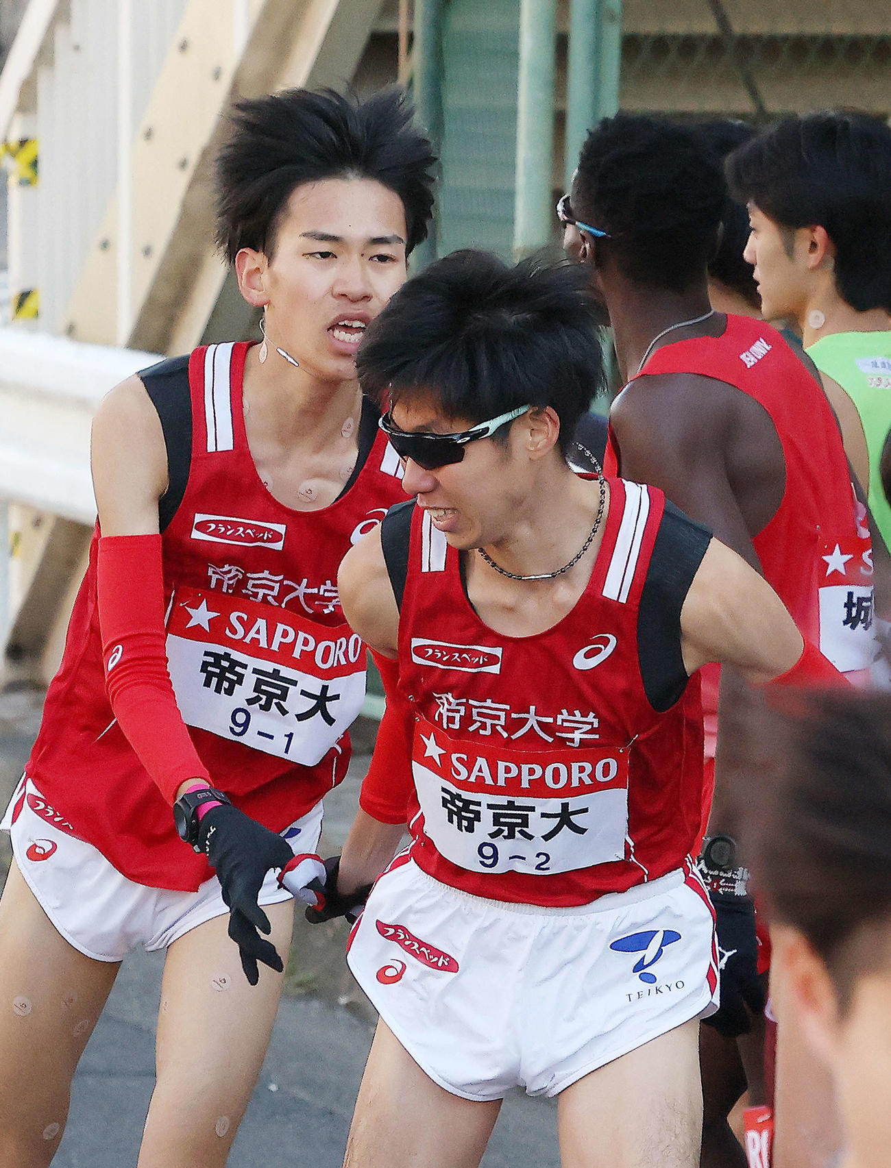 鶴見中継所を5位でタスキリレーする帝京大1区島田（左）と2区山中（撮影・河田真司）