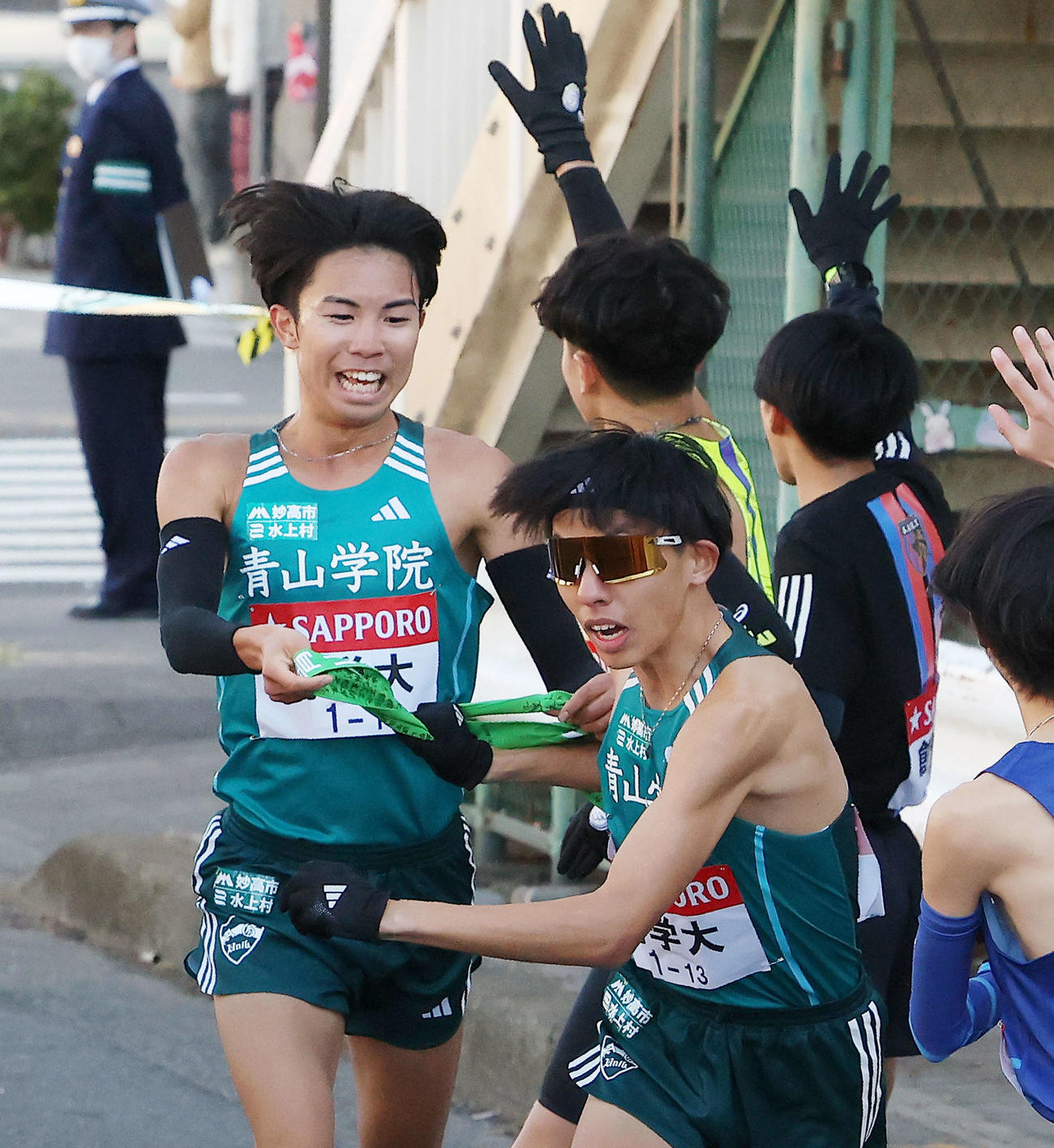 鶴見中継所を10位でタスキリレーする青学大1区宇田川（左）と2区黒田朝（撮影・河田真司）