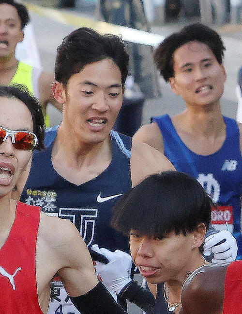 鶴見中継所を11位でタスキリレーする東洋大1区小林（左）と2区緒方（撮影・河田真司）