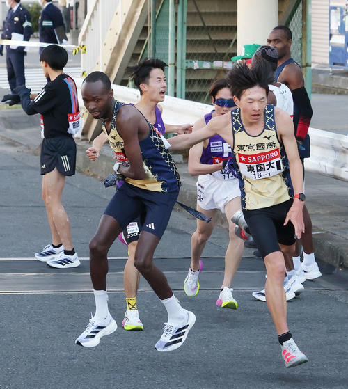 鶴見中継所を14位でタスキリレーする東京国際大1区木村（右）と2区エティーリ（撮影・河田真司）