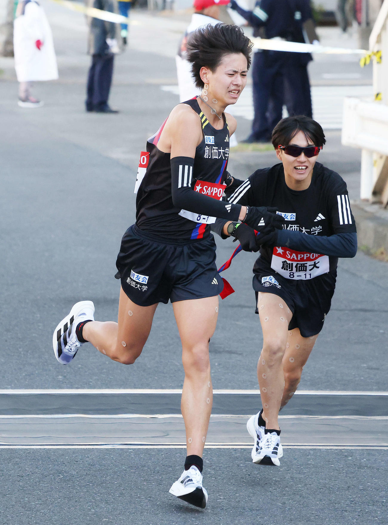 鶴見中継所を18位でタスキリレーする創価大1区斉藤大（左）と2区吉田響（撮影・河田真司）