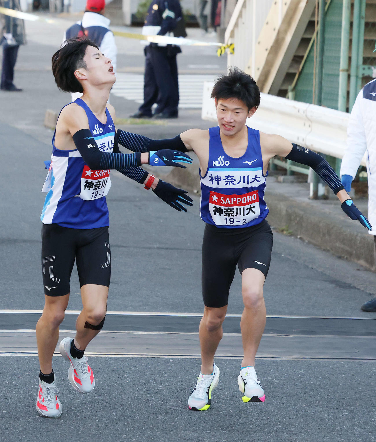 鶴見中継所を21位でタスキリレーする神奈川大1区大岩（左）と2区宮本（撮影・河田真司）
