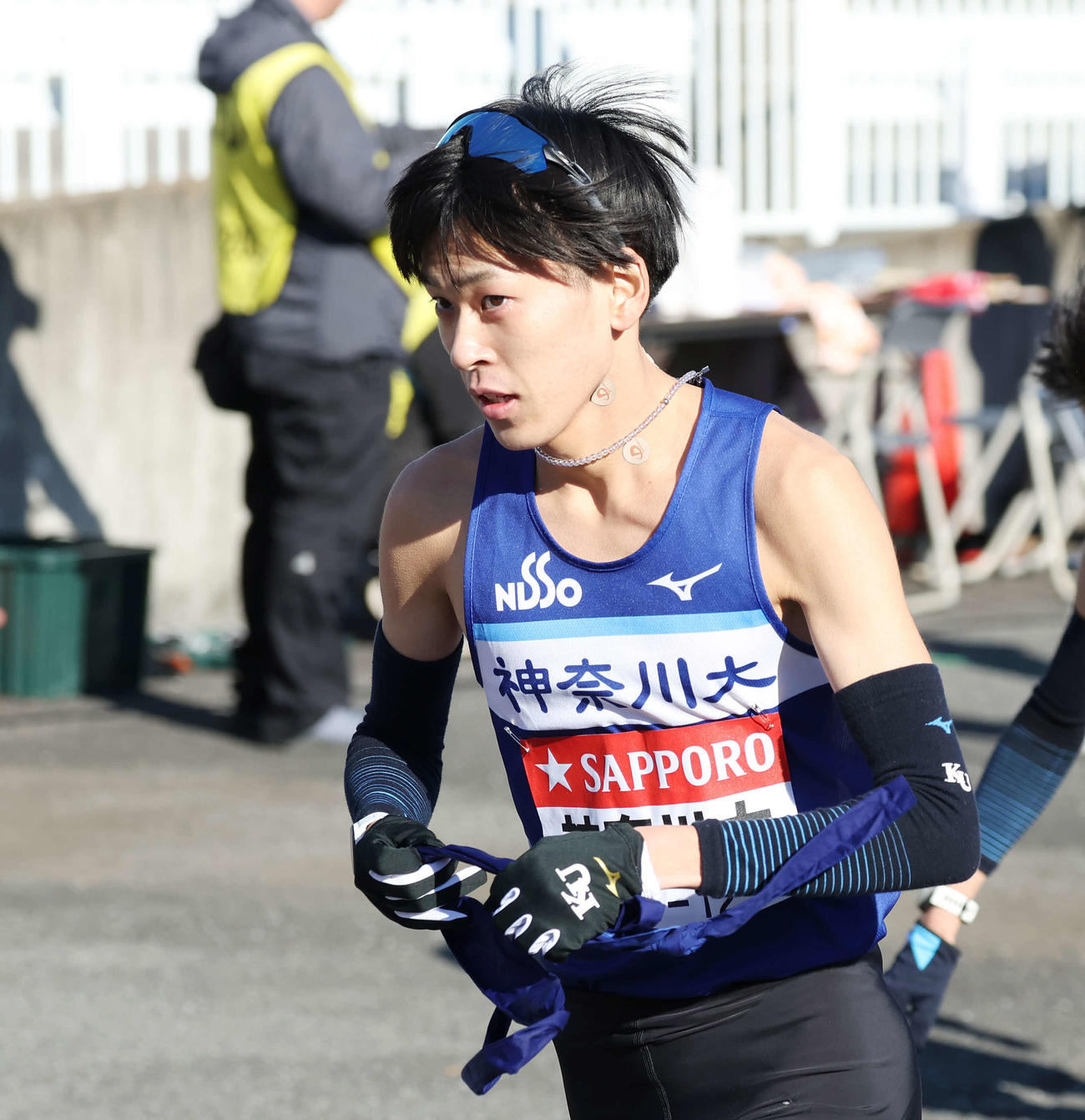 戸塚中継所でタスキを受け駆け出す神奈川大3区酒井（撮影・宮地輝）