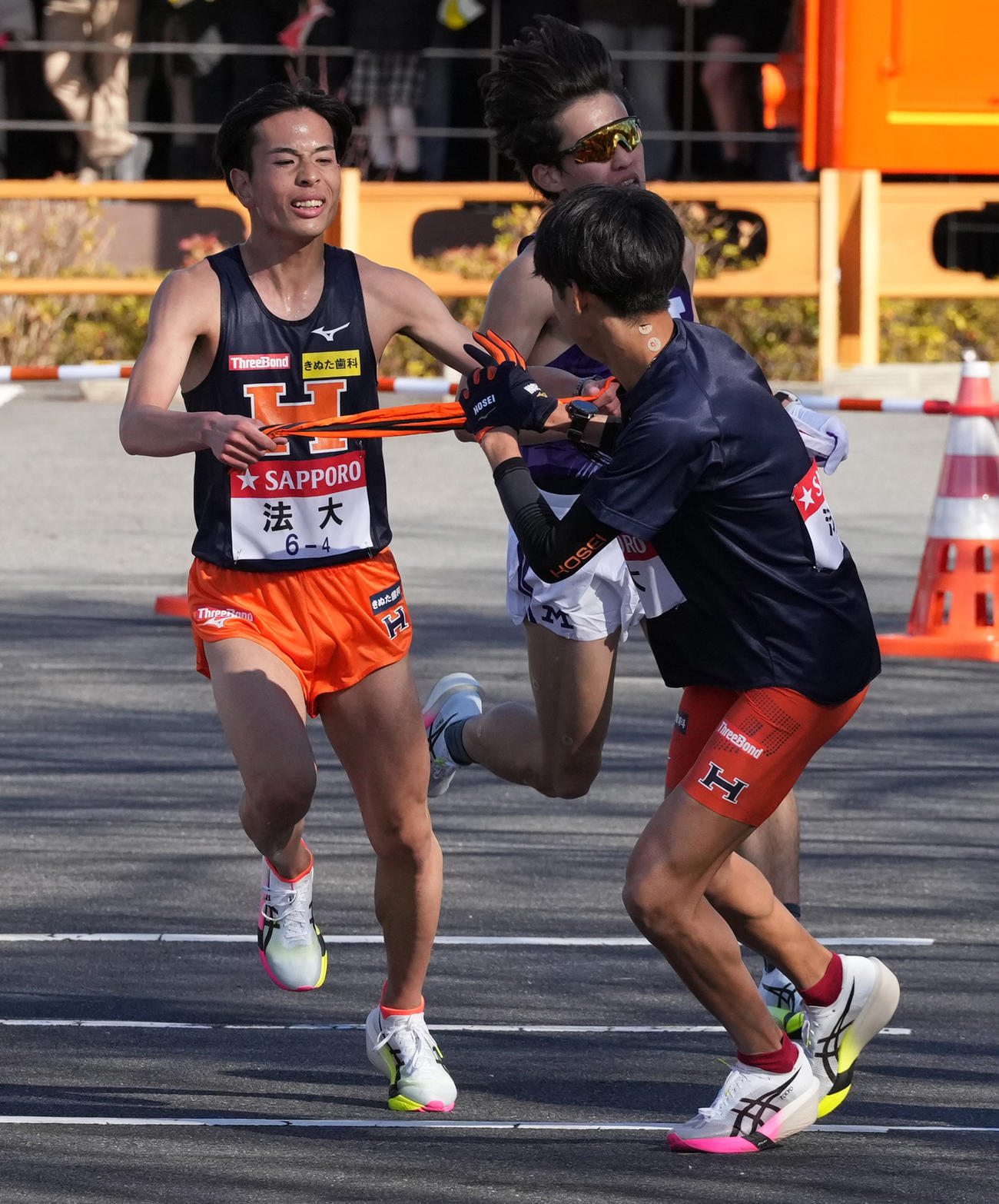 法大4区花岡（左）は5区野田に小田原中継所でたすきを渡す（撮影・鈴木みどり）