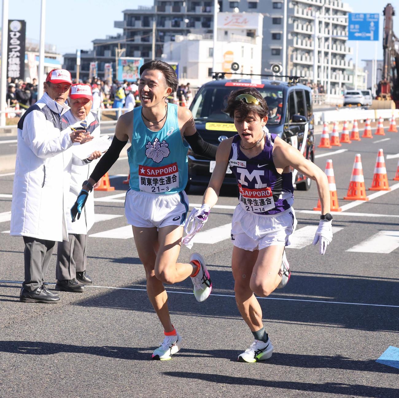 平塚中継所でタスキをつなぐ関東学生連合3区の筑波大・小山洋生（左）と4区の明大・溝上稜斗（代表撮影）