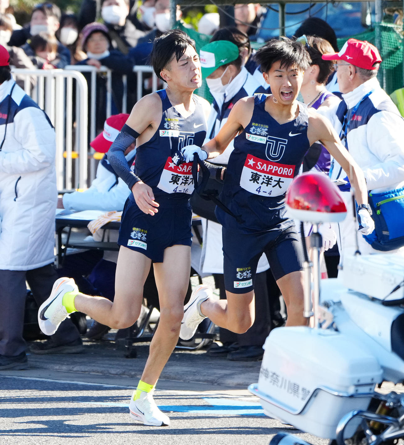 平塚中継所で東洋大3区迎（左）からタスキを受け取る4区岸本（撮影・江口和貴）