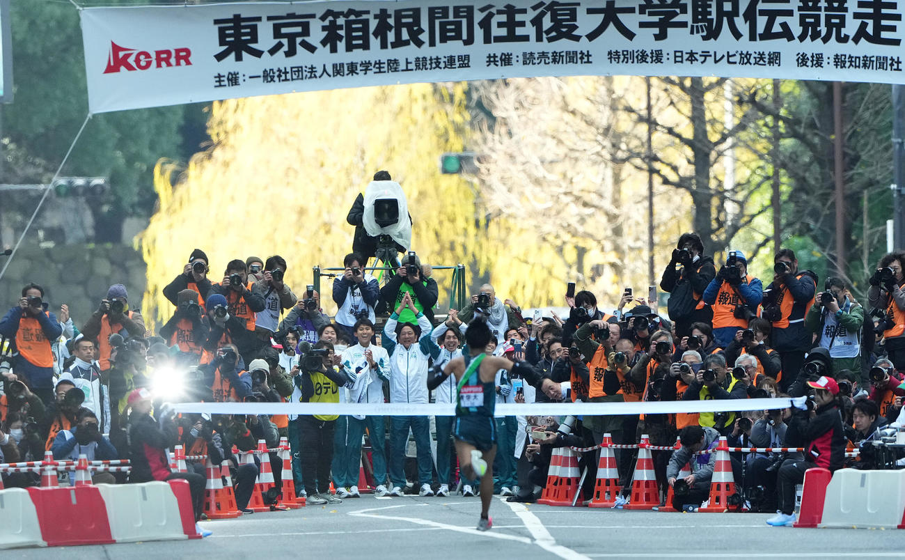 1位でゴールテープをきる青学大10区小河原陽琉を迎える原監督（中央）ら選手たち（撮影・菅敏）