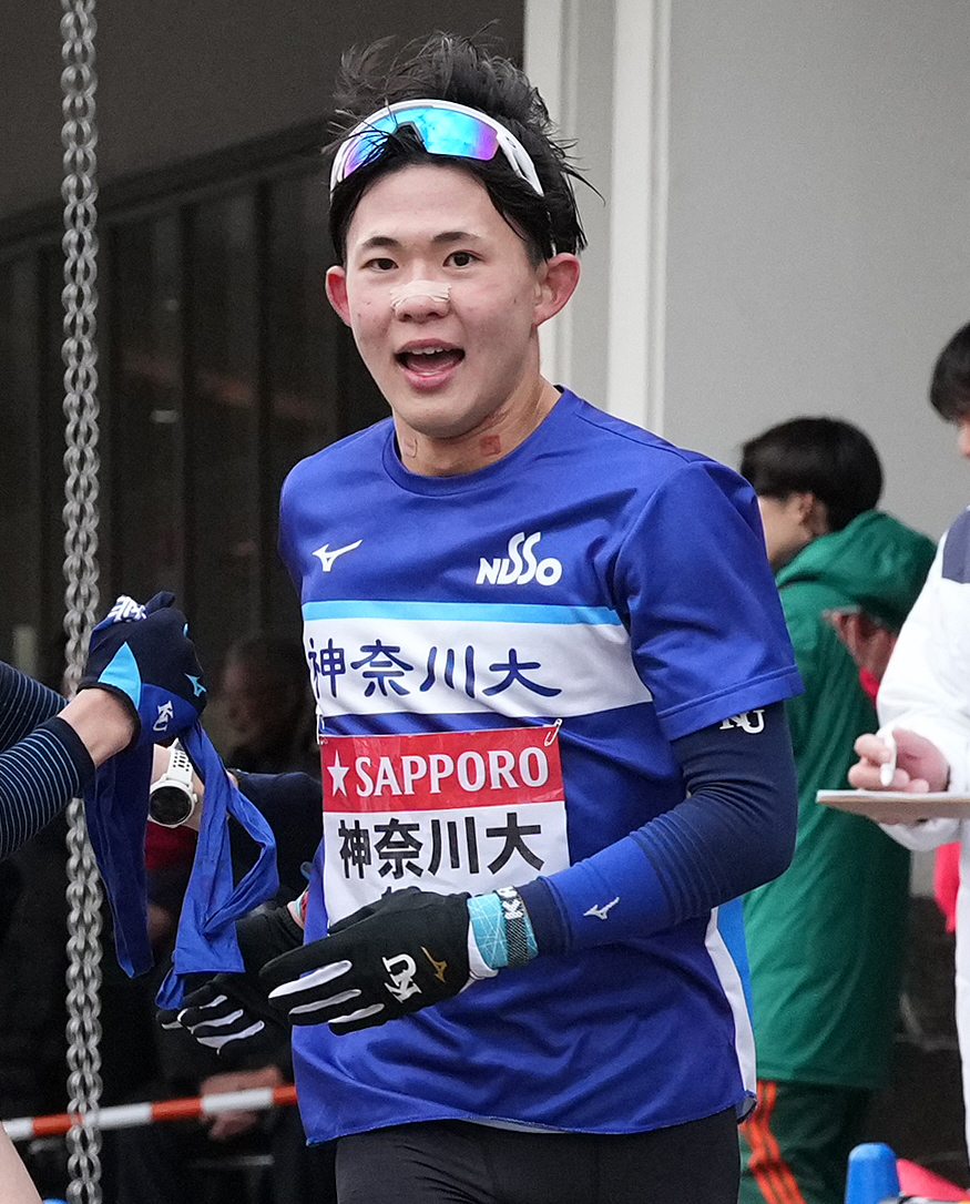 神奈川大6区上田は7区新妻に小田原中継所でたすきを渡す（撮影・鈴木みどり）