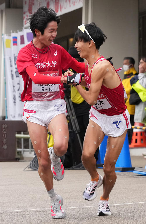 帝京大6区広田（左）は7区福田に小田原中継所でたすきを渡す（撮影・鈴木みどり）